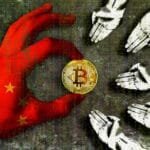 Hand holding Bitcoin with Chinese flag glove on